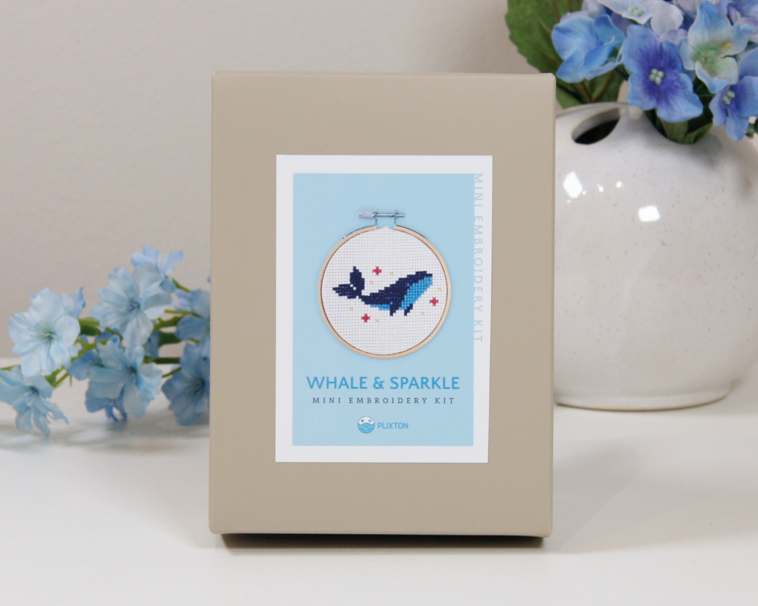 Whale & Sparkle Kreuzstichset – gestickter blauer Wal im Holzrahmen mit kleinen Sternen.