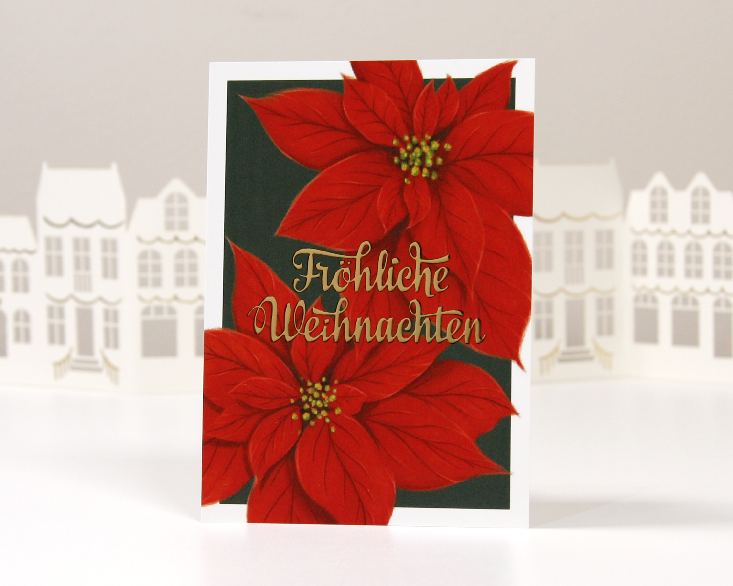 Festliche Grußkarte mit Poinsettia-Motiv und Schriftzug in Gold auf dunkelgrünem Hintergrund