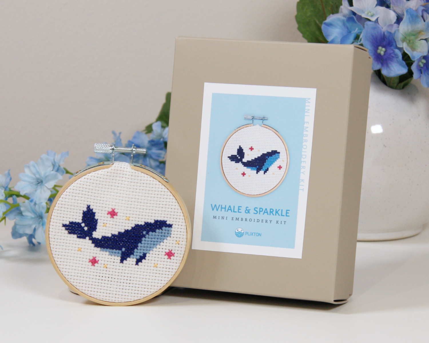 Whale & Sparkle Kreuzstichset – gestickter blauer Wal im Holzrahmen mit kleinen Sternen.